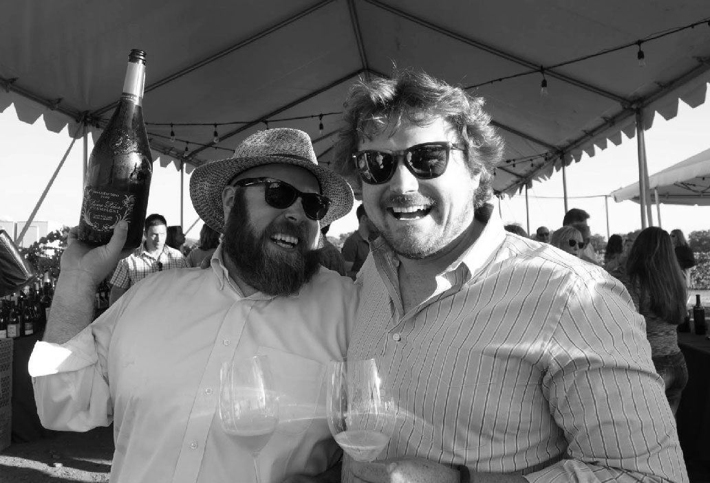 Chris Cottrell and Morgan Twain-Peterson holding a champagne bottle at a Bedrock harvest party