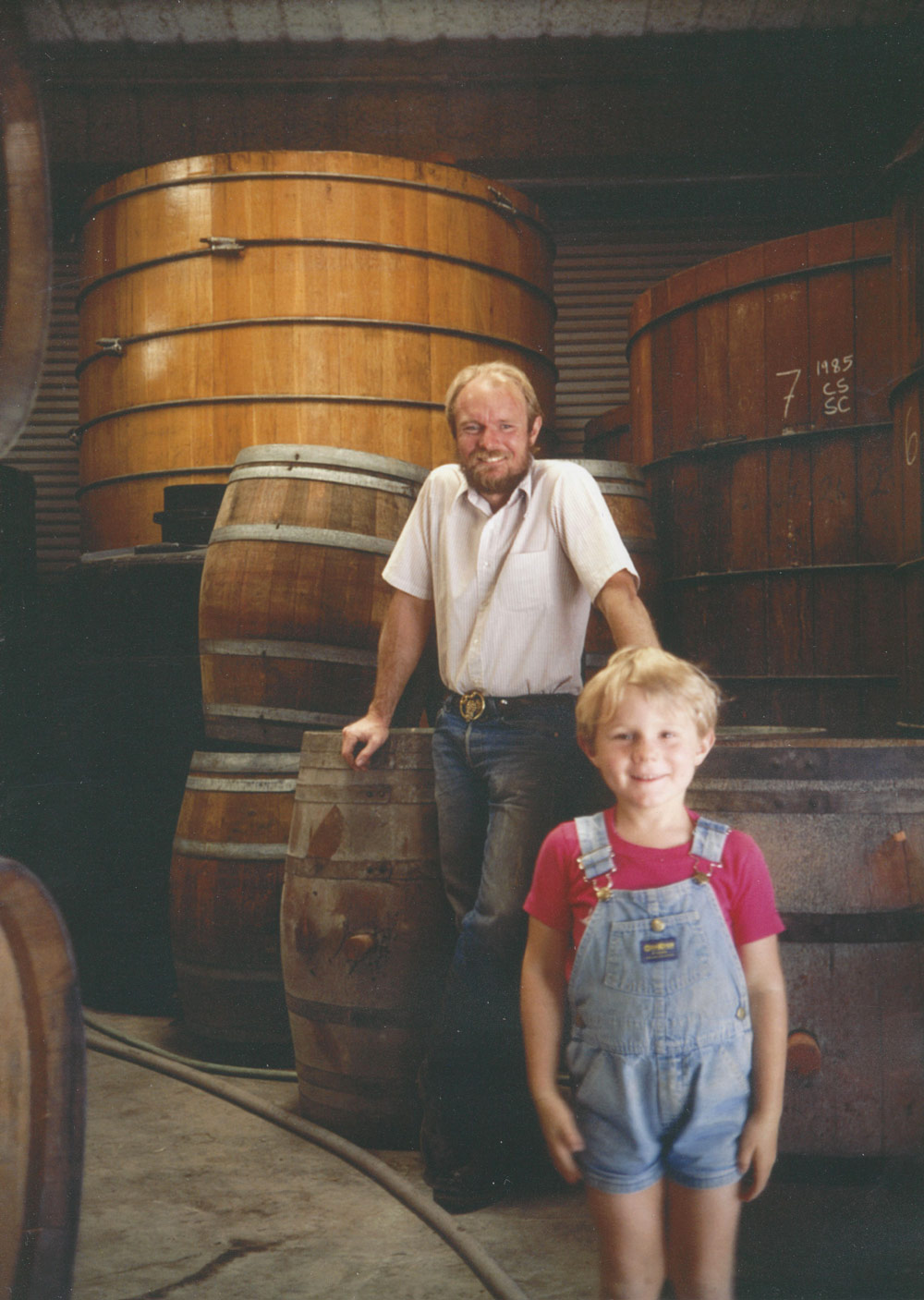 Joel Peterson and 7-year-old Morgan Twain-Peterson in Ravenswood Winery, in the 1980s