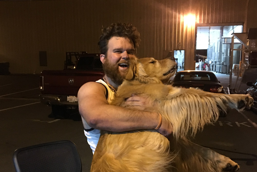 Cellarmaster Luke Nio holding golden retriever Kinley